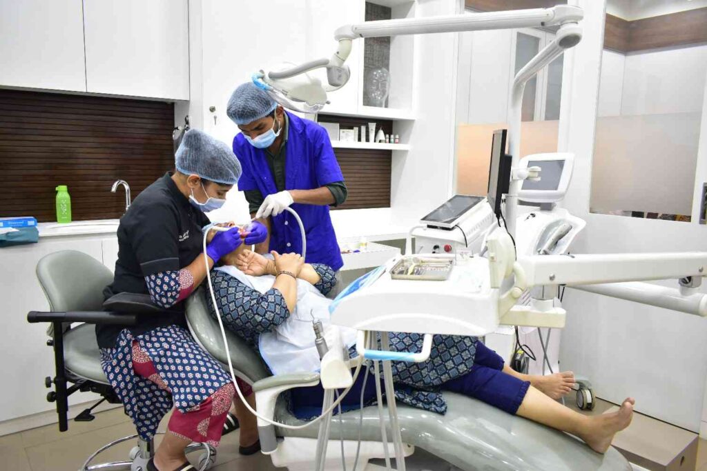 Dental doctor and assistant performing a dental procedure on a patient using modern dental equipment in a sterile clinic.
